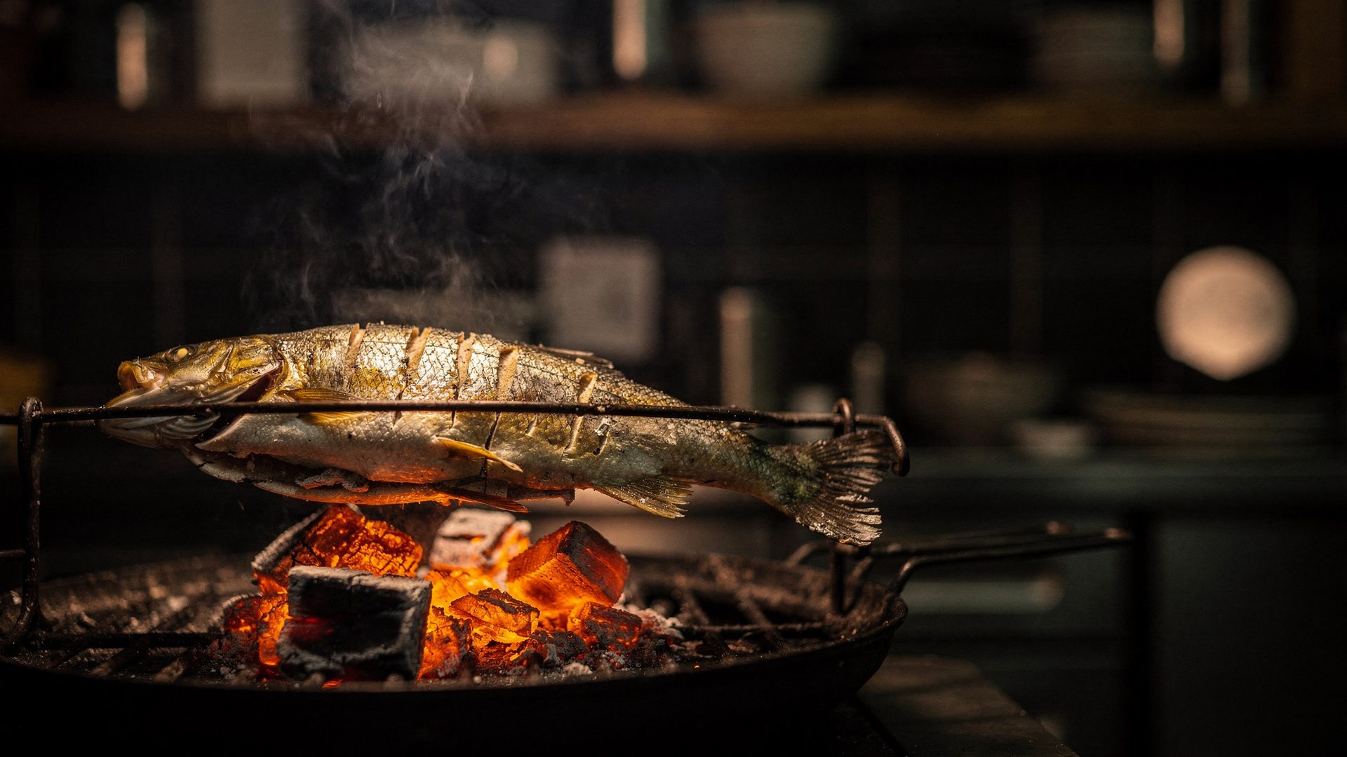 炭火で焼かれる一尾の魚